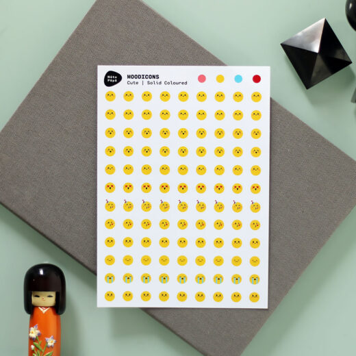 Productfotografie Moodicons Stickervel – Cute, op bureau met notitieboekje, kokeshi pop kawaii en geometrische stenen