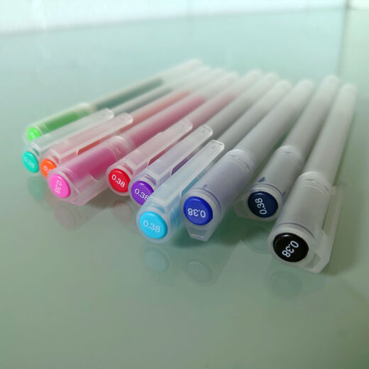 Noto Pepa Productfotografie MUJI Gel Inktpen Dop - Set van 10 (0,38mm) Kleuren op bureau, gezien vanaf de dop diagonaal