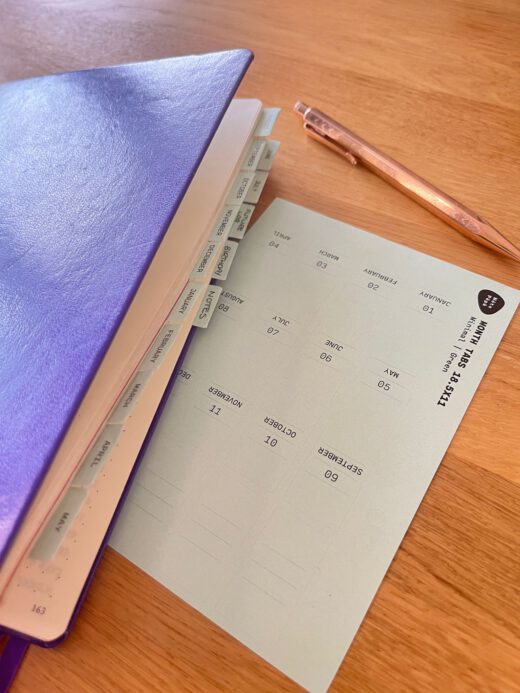 Noto Pepa Minty Green Month Tabs Stickervel, echt gebruik houten bureau, paars notitieboekje met rosé pen