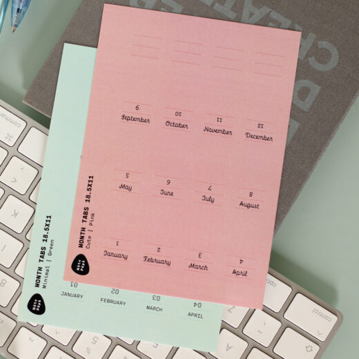 Noto Pepa Peachy Pink & Minty Green Maand Tabs Stickersheet Minimalistisch & Cute stijl voor een jaar op het toetsenbord en bullet journal op een bureau op kantoor